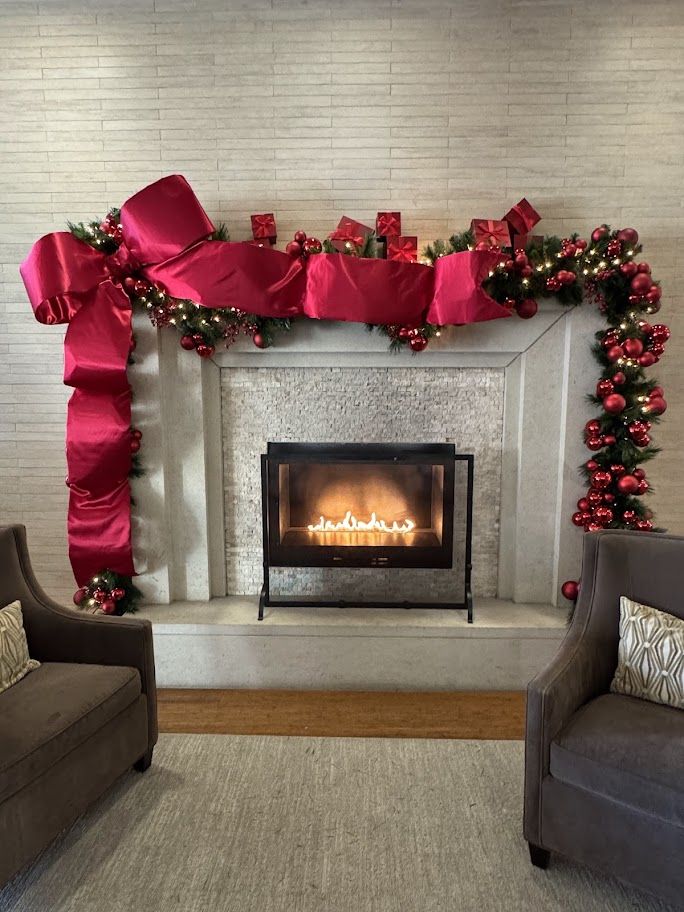 Red ribbon and ornament garland over a fireplace