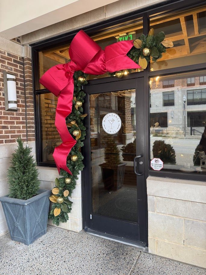 Red bow and magnolia garland on a restaurant door