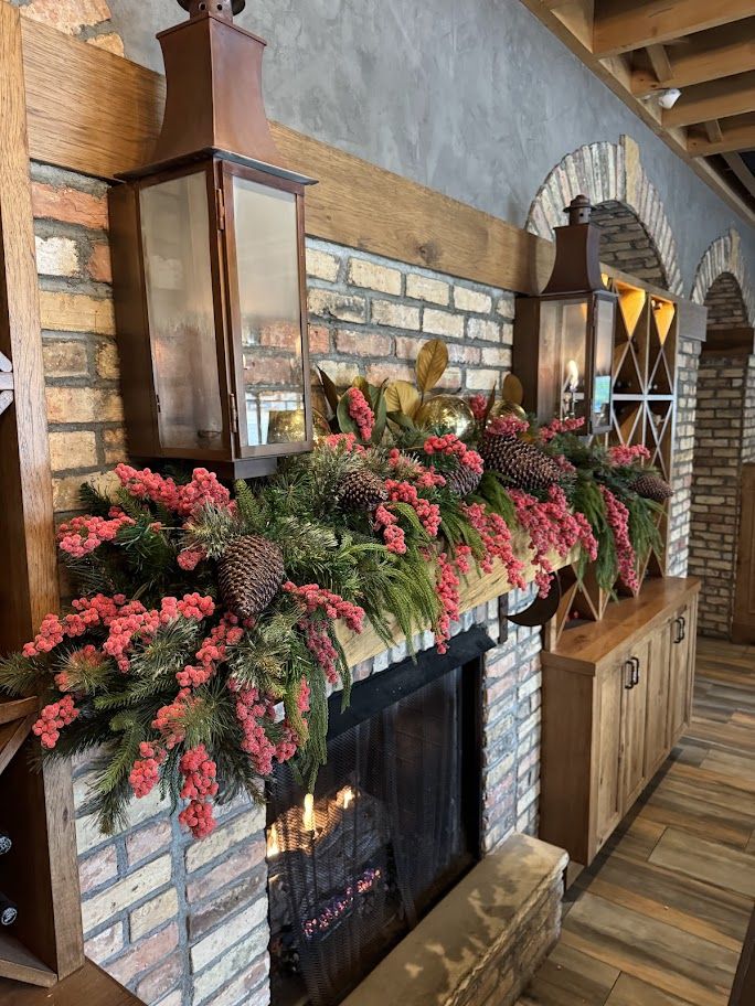 Coral berry garland along a rustic brick fireplace